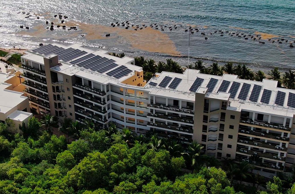 Vista aérea de hotel con paneles solares instalados en el techo, como solución energética para verano.