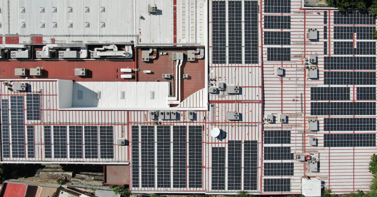 Vista aérea de planta industrial con sistema solar on-site instalado en techo metálico